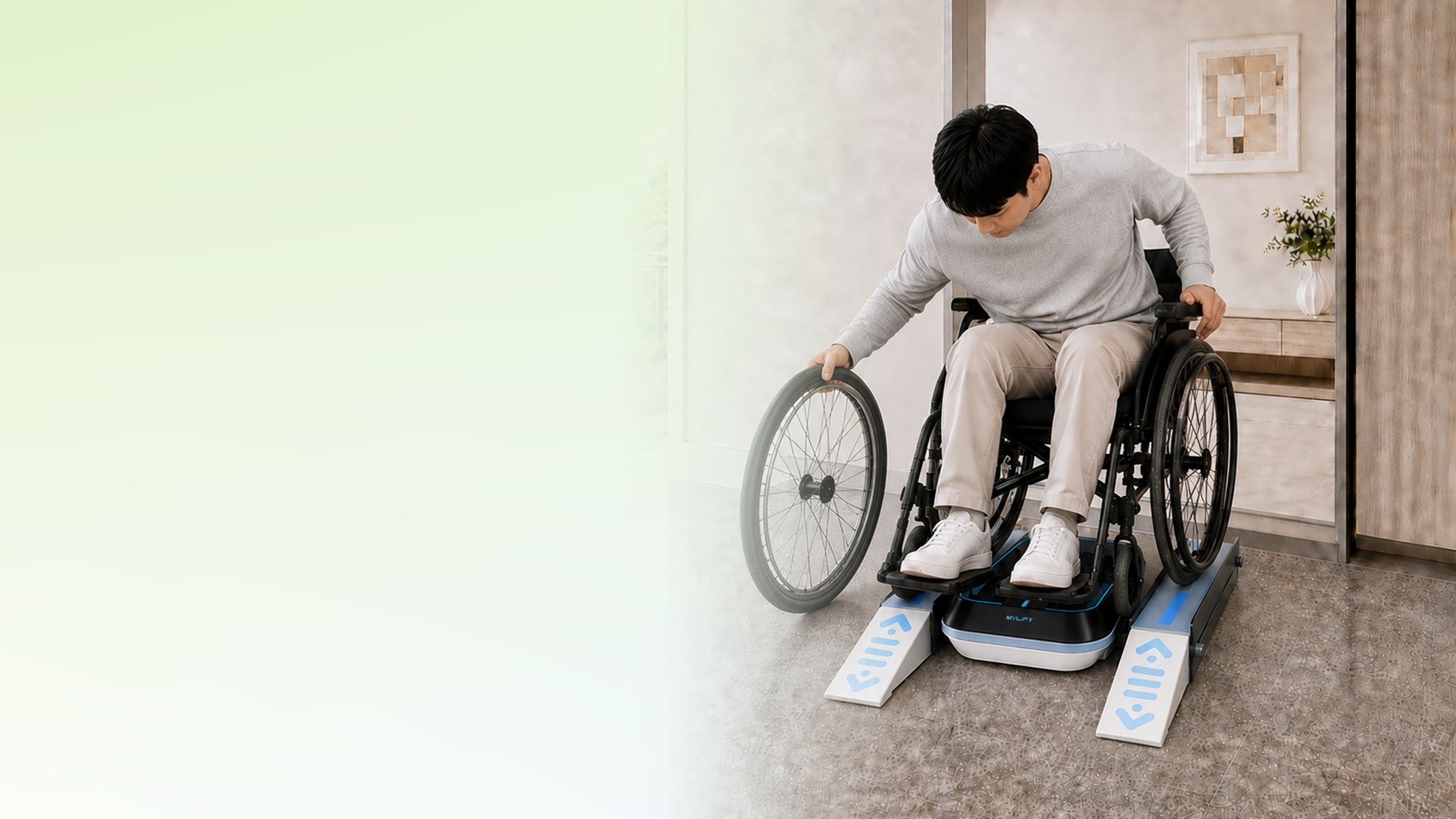 집 안에서 MYLIFT 위에 올라 앉은 채로 휠을 교체하는 휠체어 사용자